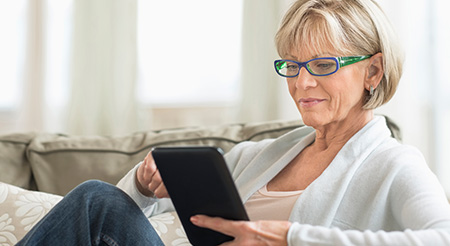 A senior is looking at her tablet